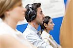 Young man sitting, wearing headphones