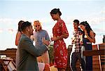 Man proposing to woman on roof terrace, sunset in background