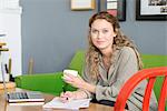 Portrait of young female designer on office sofa