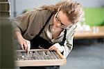 Woman choosing letterpress from tray in print workshop