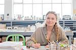 Portrait of female print designer working on sketchbook in workshop