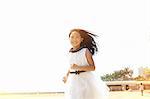 Girl wearing white dress running on beach, Zhuhai, Guangdong, China