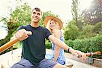 Young couple rowing boat on rural river