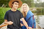 Portrait of young couple in river rowing boat