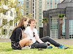Young couple having coffee break on grass, Melbourne, Victoria, Australia