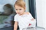 Portrait of female toddler on patio eating  bowl of raspberries