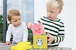 Boy and female toddler playing with building blocks on patio