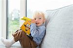 Portrait of male toddler playing with building blocks on sofa
