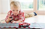 Boy playing with toy  racing car on living room floor