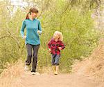 Mother and son running in forest