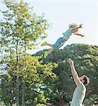 Father throwing son in air, outdoors