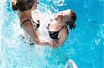 Teenage girls splashing in swimming pool