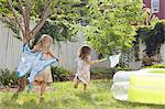 Girls in butterfly costumes playing in garden