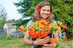 Portrait of female farm worker holding a bucket of fresh cut flowers