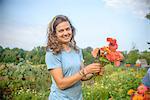 Portrait of female farm worker holding a bunch of fresh cut flowers