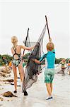 Children learning how to use traditional fishing net, Sanibel Island, Pine Island Sound, Florida, USA