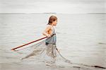 Girl learning how to use traditional fishing net, Sanibel Island, Pine Island Sound, Florida, USA