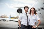 Portrait of male and female private jet pilots at airport