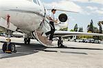 Male private jet pilot stepping from plane at airport