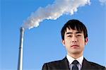 Businessman in Front of Smokestack