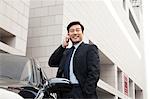 businessman making phone call beside the car