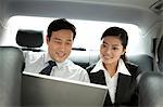 business people working with laptop in the car