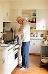 Man standing in a kitchen, making coffee.