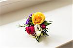 groom's boutonniere of roses and different flowers