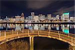 Portland Oregon downtown city skyline from pedestrian bridge along Willamette River at night