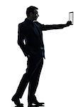 one  business man holding digital tablet in silhouette on white background