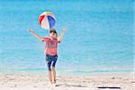 playful little boy playing with beach ball at the caribbean beach