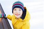 little boy enjoying cold winter weather and ice skating at outdoor rink