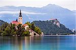 Little Island with Catholic Church and Bled Castle on Bled Lake, Slovenia with Mountains in Background