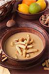 Cream soup lentils with croutons in a clay plate.