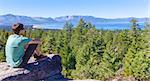 panorama of young man resting after hike and enjoying gorgeous view at lake tahoe at summer