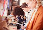 People working and drinking coffee in a row in cafe