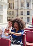 Couple taking selfie on double-decker bus