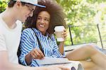 College students drinking coffee and studying in park