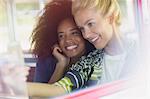 Smiling friends taking selfie on bus