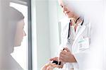 Doctor testing patient blood sugar for diabetes in examination room