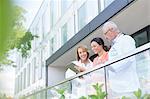 Doctors and nurse reviewing medical record on hospital balcony