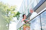 Doctor and nurse with digital tablet talking on hospital balcony