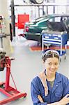 Portrait confident mechanic with arms crossed in auto repair shop