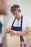 Carpenter measuring wood in workshop