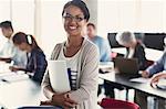 Portrait confident adult education student with books in classroom