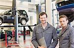 Portrait confident mechanics in auto repair shop