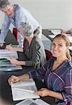 Portrait smiling student with textbook in adult education classroom