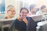 Smiling women at computer in adult education classroom