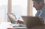 Focused businessman taking notes in meeting