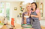 Portrait smiling grandmother and granddaughter baking in kitchen